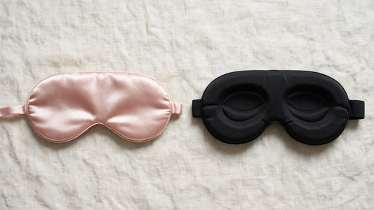 Eine rosa Seidenschlafmaske und eine schwarze Schaumstoff-Schlafmaske im Vergleich